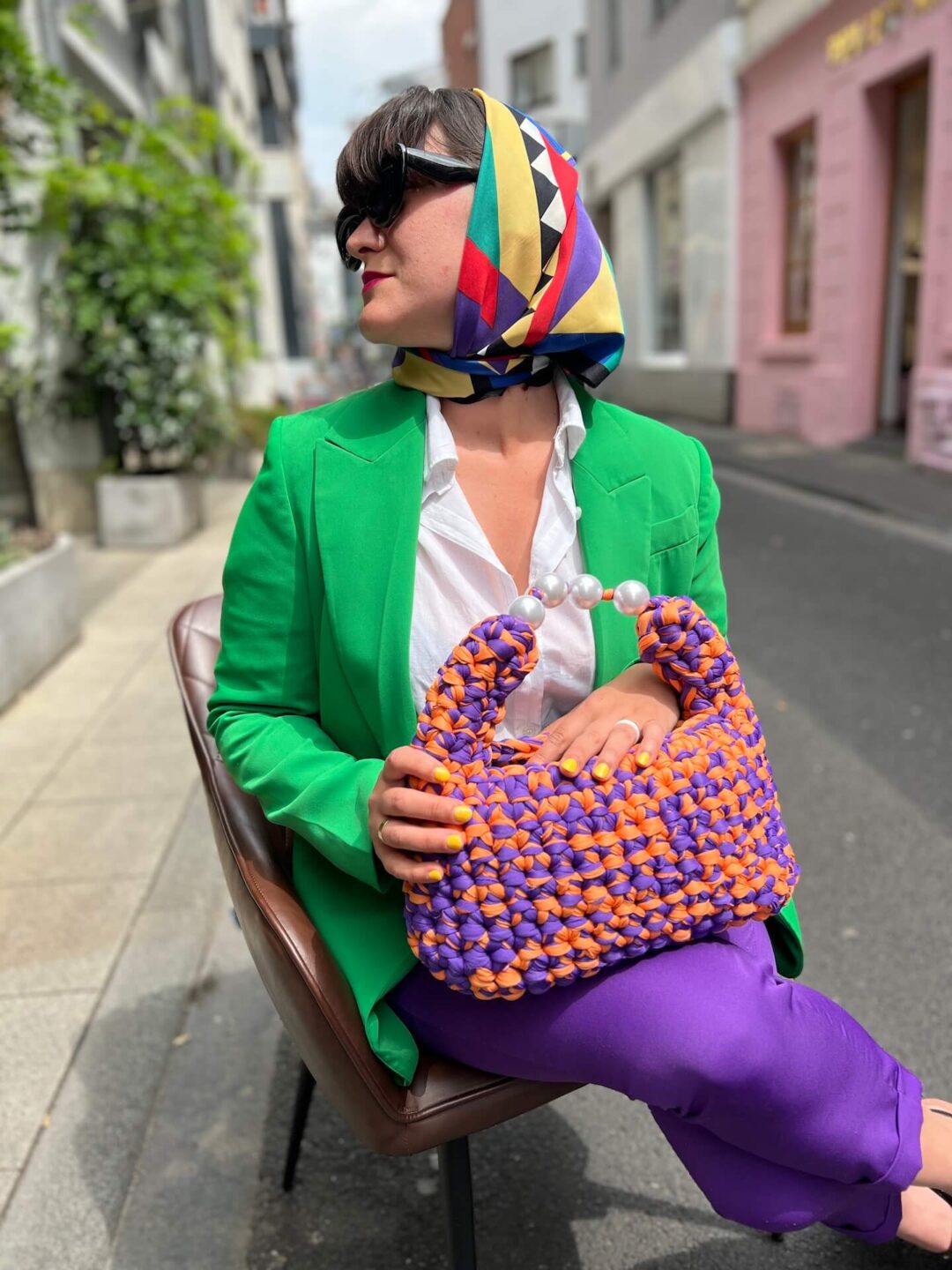 Handmade crochet Viola bag in vibrant purple and orange, crafted from Italian Lycra Fetucia yarn with a pearl handle – limited edition designer accessory by InaPavl.
